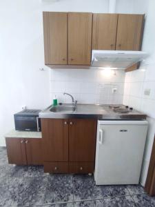 a small kitchen with a sink and a refrigerator at Peristerianos apartments in Nea Skioni