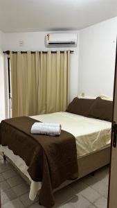 a bedroom with a bed with a brown blanket on it at Apartamento inteiro frente ao mar de ondina in Salvador