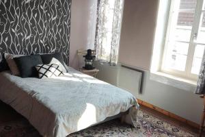a bedroom with a bed with a patterned wall at MAISON DE VACANCES aU 91 in Ardres