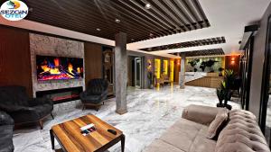 a living room with a couch and a fireplace at Sezgin Hotel in Uzungol