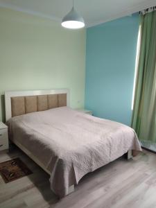 sypialnia z łóżkiem z kocem w obiekcie Nunu's Guesthouse w mieście Ckaltubo
