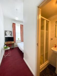 a hotel room with a bed and a bathroom at Orlando hotel in London