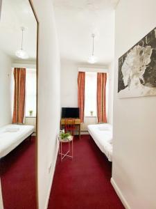 Habitación con 2 camas y espejo. en Orlando hotel, en Londres