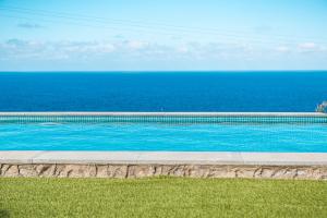 a swimming pool with the ocean in the background at La Candia y el Mar in Valverde