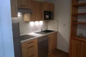 a small kitchen with a sink and a microwave at Deux pièces Monêtier-les-Bains (Serre-Chevalier) in Le Monêtier-les-Bains +10 photos