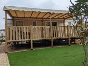 a deck with a pergola on a house at Mobil home 6/8personnes in Sérignan