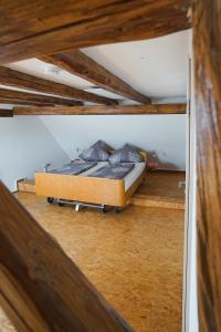 a bed in a room with a wooden ceiling at Rhöner Heim in Kaltennordheim