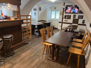 un restaurante con mesas y sillas y un bar en H@M Penzion, en Žlutice