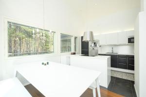 a kitchen with white cabinets and a large window at Villa Tuomipakka in Kalajoki