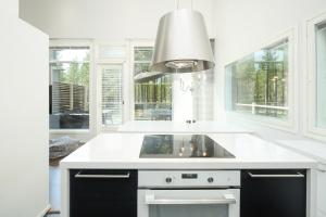 a white kitchen with a sink and windows at Villa Tuomipakka in Kalajoki