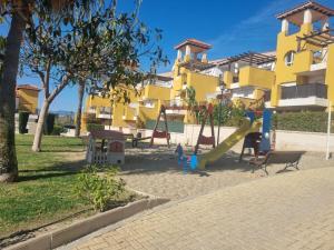einen Spielplatz vor einem gelben Gebäude in der Unterkunft SALINAS DE VERA APARTAMENTO in Vera