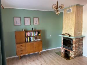 a living room with a book shelf and a fireplace at Kisielkowo in Wilkasy