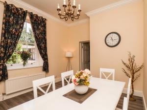 a dining room with a white table and a vase with flowers at The Cottage in Yarm