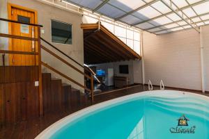 ein großer Pool in einem Gebäude mit einer Treppe in der Unterkunft Hotel Morada Del Este in Canoas