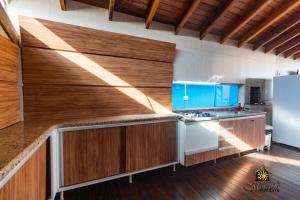 - une cuisine avec des placards en bois et un réfrigérateur blanc dans l'établissement Hotel Morada Del Este, à Canoas