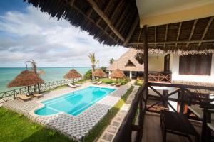 une image d'une villa avec une piscine et l'océan dans l'établissement Mahi Mahi Beach Hotel, à Jambiani