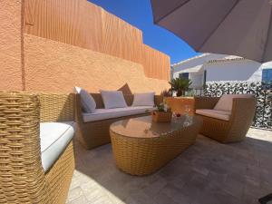 a patio with wicker chairs and a table and an umbrella at Nice Holiday Home - Sol Espanol in Sitio de Calahonda