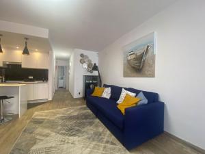 a living room with a blue couch and a kitchen at Nice Holiday Home - Sol Espanol in Sitio de Calahonda