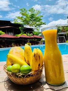 Una cesta de fruta junto a una botella de zumo. en Madera Labrada Lodge Ecologico en Tarapoto