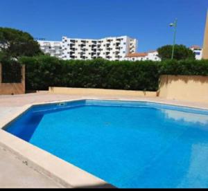 a large blue swimming pool in front of a building at Résidence au soleil avec Piscine à 150m de la plage - Barcarès in Le Barcarès