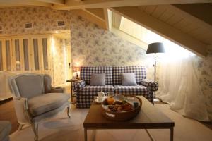 a living room with a couch and a bowl of fruit on a table at Las Doñas del Portazgo in Villafranca del Bierzo