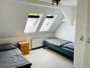 a attic bedroom with two beds and two windows at Ferienhaus Kyritz Gantikow in Mechow