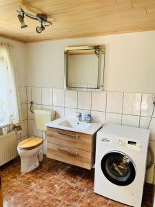a bathroom with a sink and a washing machine at Ferienhaus Kyritz Gantikow in Mechow +7 photos