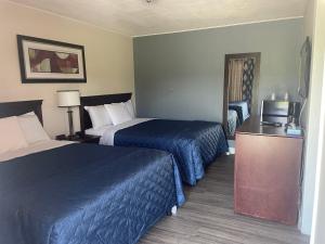 Nites Inn Motel في كورنوول: غرفه فندقيه سريرين وتلفزيون