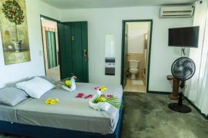 a bedroom with a bed with flowers and a fan at La Puesta del Sol B&B in Carrillo