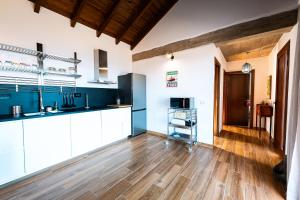 a kitchen with white cabinets and a wooden floor at La Candia y el Mar in Valverde
