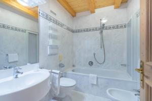 uma casa de banho com uma banheira, um WC e um lavatório. em Hotel Ciamp em Santa Cristina in Val Gardena