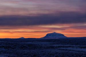 een berg in de woestijn onder een zonsondergang bij Grímstunga Guesthouse in Víðirhóll