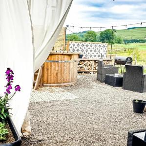 a patio with a white tent and a table and chairs at The Wee Stay - Rural Guest Suite with Woodfired Hot Tub and outside Kitchen and covered Livingroom area in Crook of Devon