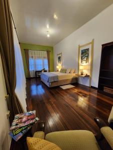 um quarto amplo com uma cama e piso em madeira em Queen Maxima by Prins Hendrik Suites em Paramaribo