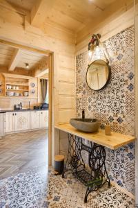 a bathroom with a sink and a mirror on the wall at Domki Cepersko Ostoja w Kościelisku in Kościelisko