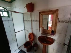ein Badezimmer mit einem WC, einem Waschbecken und einem Spiegel in der Unterkunft Pouso Jequitibá in Tiradentes