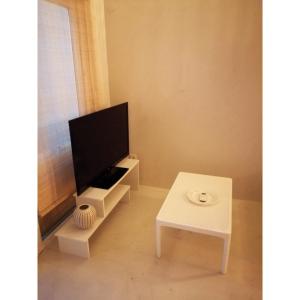 a living room with a tv and a table at Alos 2 in Ammouliani