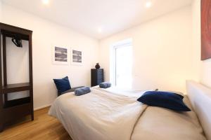 a bedroom with a large white bed with blue pillows at WOHNEN BAHNSTRASSE 5 in Klagenfurt