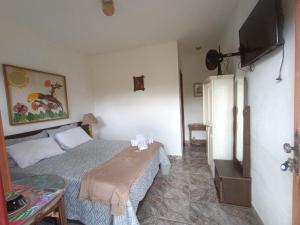 ein kleines Schlafzimmer mit einem Bett und einem Kühlschrank in der Unterkunft Pouso Jequitibá in Tiradentes