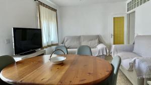 sala de estar con mesa de madera y TV en Torroella 3, en L'Estartit