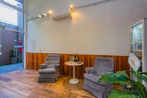 una sala de espera con 2 sillas y una mesa en Hotel Morada Del Este en Canoas