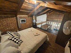 a bedroom with a large bed in a brick wall at Hot Chipilin in Antigua Guatemala