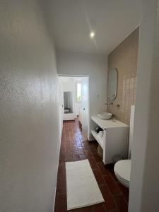 La salle de bains est pourvue de toilettes, d'un lavabo et d'un miroir. dans l'établissement Guesthouse Casa Felicia, à Montes de Alvor