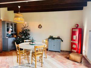 uma sala de jantar com uma mesa e uma árvore de Natal em L'ILEAU em La Taillée