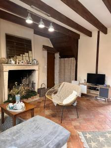 uma sala de estar com um sofá e uma lareira em L'ILEAU em La Taillée