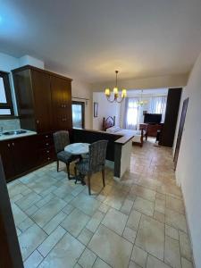 a kitchen with a table and chairs and a living room at Palm Villa Private Studio in Phrenaros