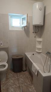 een badkamer met een toilet, een bad en een wastafel bij Apartment Ruby in Podstrana