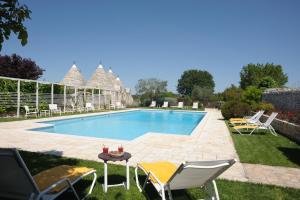 諾奇的住宿－阿巴特馬賽利雅度假酒店，庭院内的游泳池,配有椅子和桌子