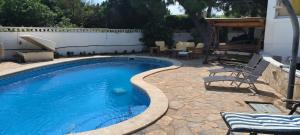 a swimming pool in a yard with chairs and a table at Cala Llanetes in Vinarós