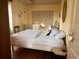 a bedroom with a large white bed in a room at L'ILEAU in La Taillée